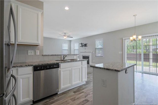 387 Springhaven Dr, Raeford, NC 28376 - kitchen with appliances with stainless steel finishes, a sink, a ceiling fan, a chandelier, and a peninsula