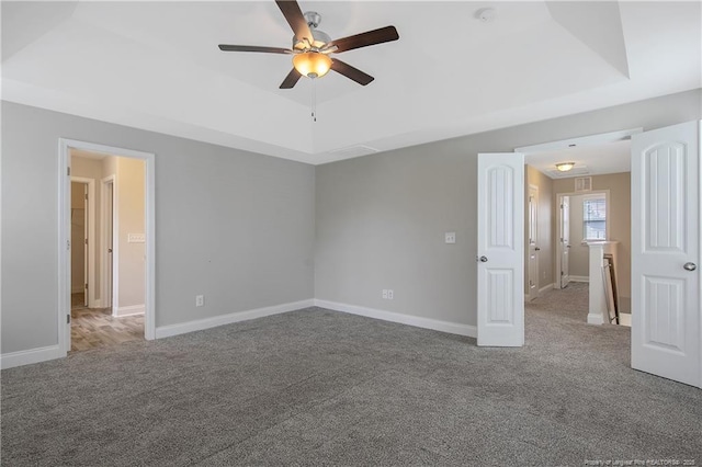 387 Springhaven Dr, Raeford, NC 28376 - unfurnished bedroom with carpet flooring, a tray ceiling, baseboards, and a ceiling fan
