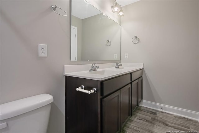 387 Springhaven Dr, Raeford, NC 28376 - bathroom featuring toilet, double vanity, wood finished floors, and baseboards