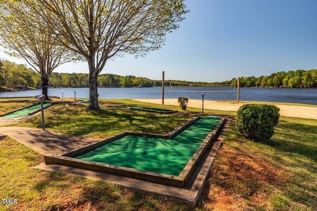 view of community featuring volleyball court, a lawn, and a water view