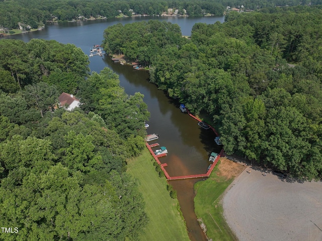 drone / aerial view with a forest view and a water view