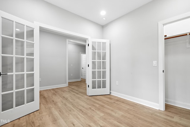 unfurnished bedroom with baseboards, recessed lighting, light wood-style flooring, french doors, and a closet