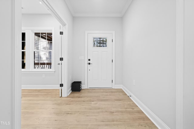 foyer with baseboards, crown molding, and light wood-style floors