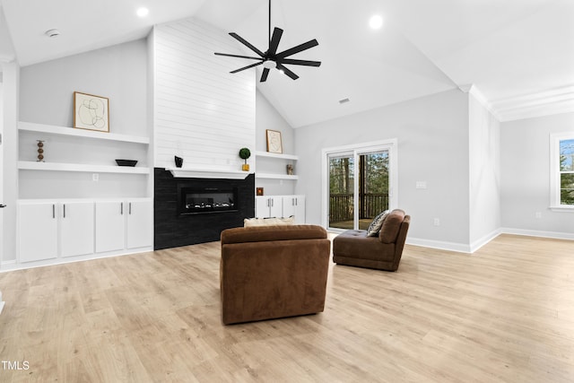 living area featuring light wood finished floors, a healthy amount of sunlight, and a fireplace