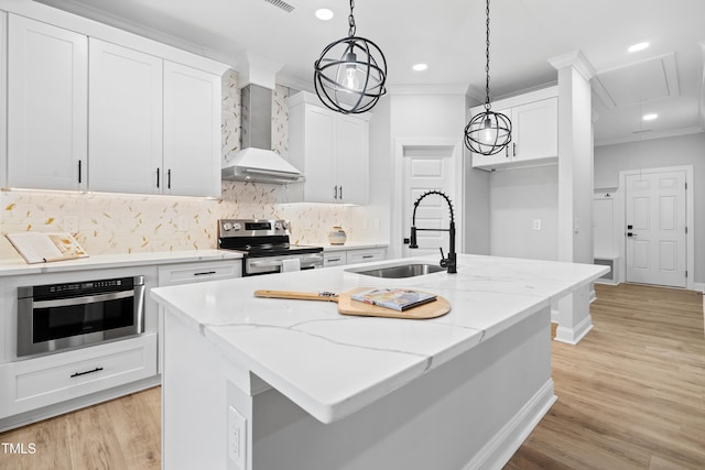 kitchen with a sink, stainless steel appliances, wall chimney exhaust hood, and ornamental molding