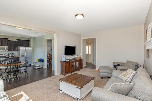 living area featuring visible vents, baseboards, a toaster, dark wood-style flooring, and dark colored carpet