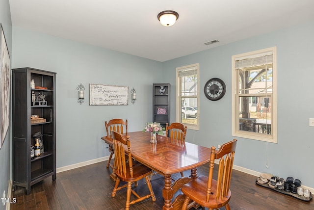 dining area featuring visible vents, dark wood-type flooring, and a healthy amount of sunlight