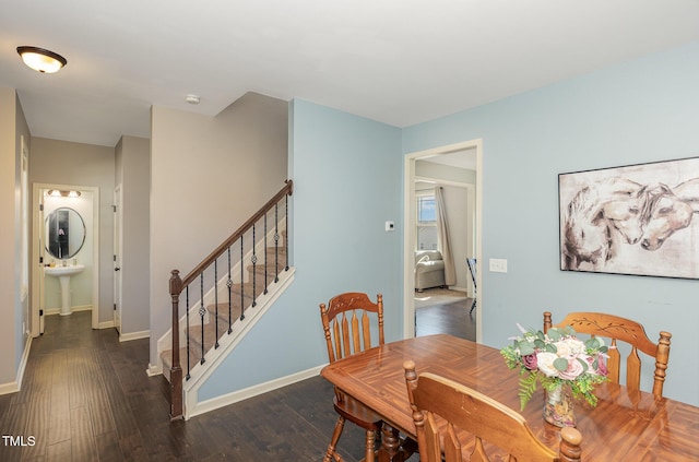 dining space featuring stairs, baseboards, and wood finished floors