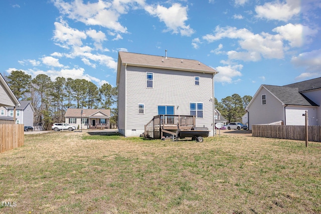 rear view of property featuring crawl space, a yard, and fence