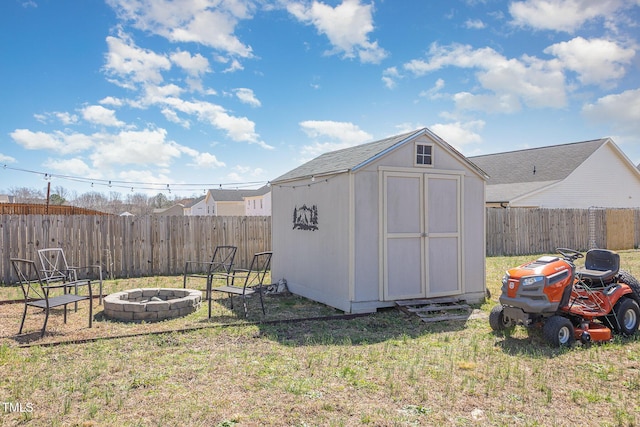 view of shed with a fenced backyard and an outdoor fire pit