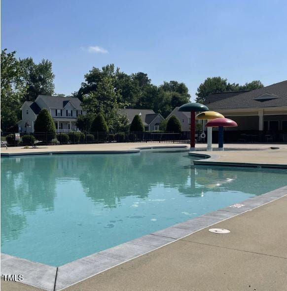 pool with a patio and fence