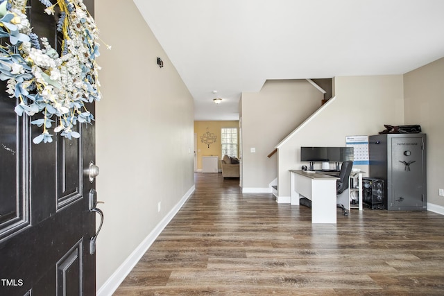 foyer entrance with stairway, baseboards, and wood finished floors