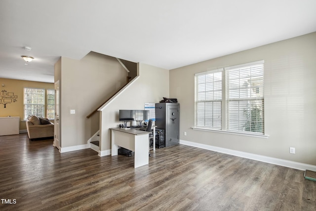 unfurnished living room with stairway, baseboards, and dark wood finished floors