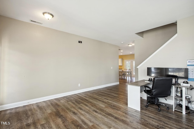 office area with dark wood-style floors, visible vents, and baseboards