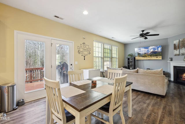 dining room with visible vents, ceiling fan, a lit fireplace, recessed lighting, and wood finished floors