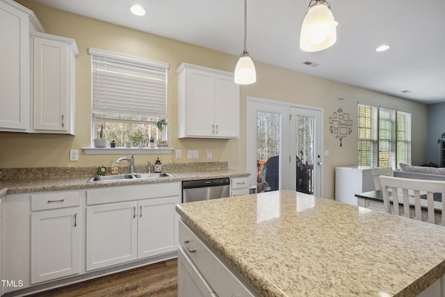 kitchen featuring visible vents, white cabinets, dishwasher, and a sink