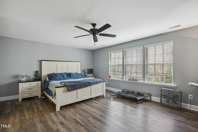 bedroom with dark wood finished floors, visible vents, ceiling fan, and baseboards