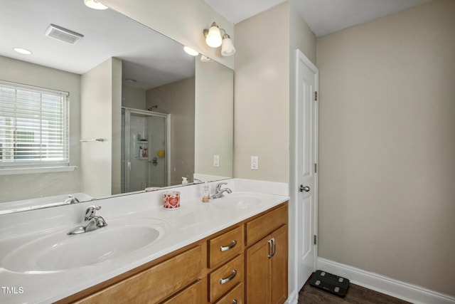 full bath with double vanity, visible vents, a stall shower, and a sink