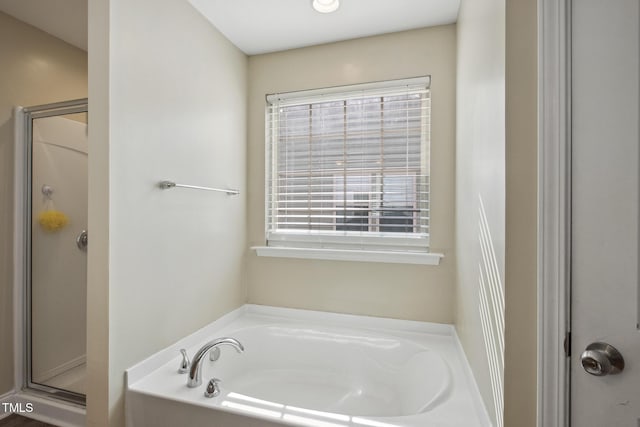 bathroom with a bath and a shower stall