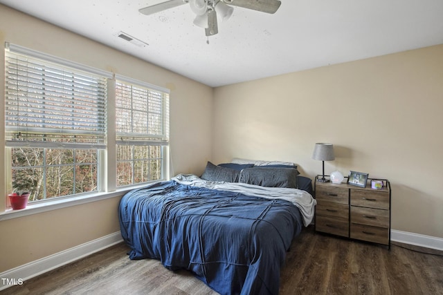 bedroom featuring visible vents, baseboards, and wood finished floors