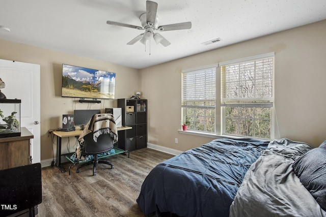 bedroom with visible vents, ceiling fan, baseboards, and wood finished floors