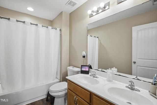 bathroom with visible vents, toilet, shower / tub combo, and a sink