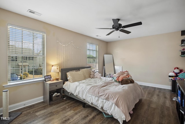 bedroom featuring a ceiling fan, visible vents, wood finished floors, and baseboards