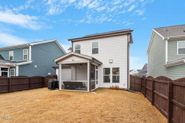 rear view of property with a lawn, a fenced backyard, and a sunroom