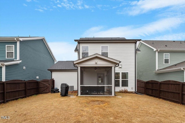 rear view of property with a gate, a lawn, a fenced backyard, and a sunroom