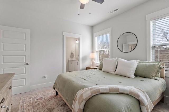 bedroom featuring visible vents, multiple windows, light colored carpet, and baseboards