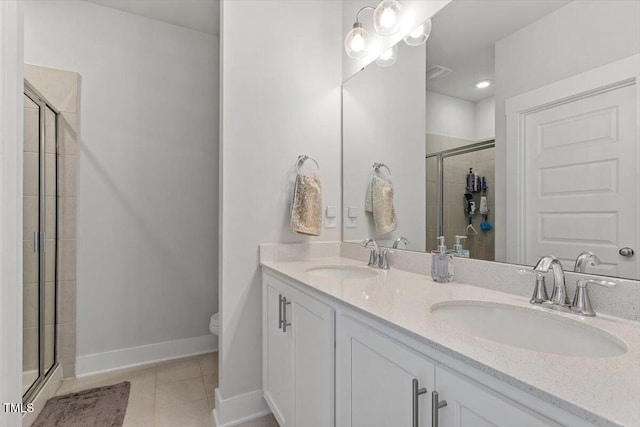 bathroom with tile patterned floors, a shower stall, toilet, and a sink