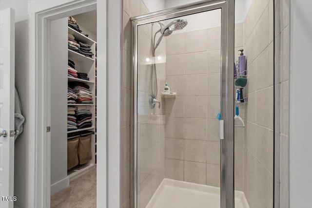 full bathroom with a walk in closet and a shower stall