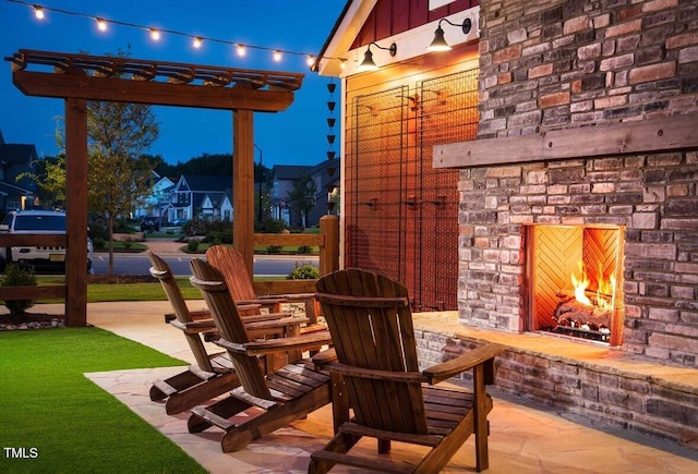 view of patio with an outdoor stone fireplace and a pergola