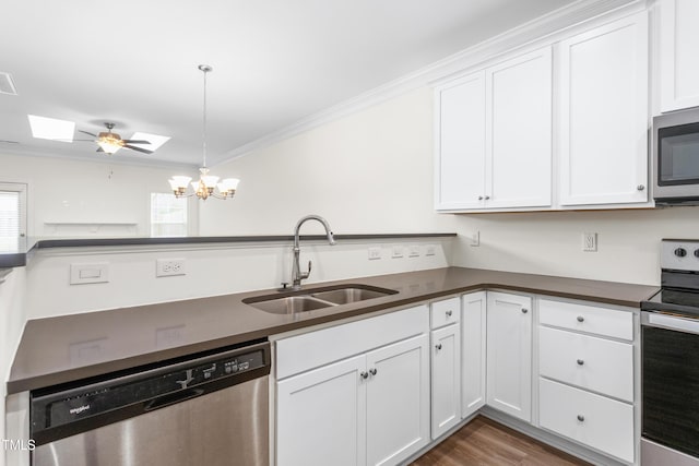 kitchen featuring dark countertops, white cabinetry, stainless steel appliances, and a sink