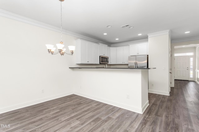 kitchen with baseboards, a peninsula, dark wood-type flooring, appliances with stainless steel finishes, and crown molding