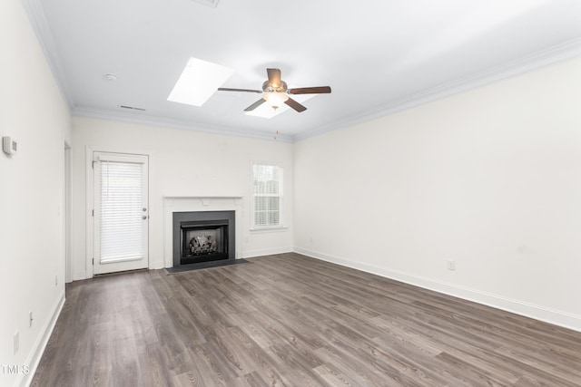 unfurnished living room featuring crown molding, ceiling fan, baseboards, a fireplace with flush hearth, and wood finished floors