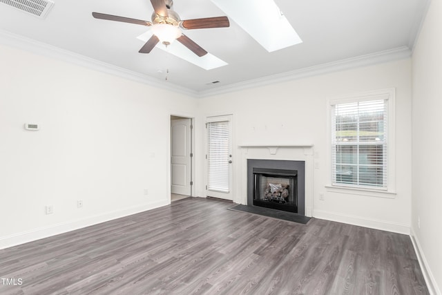 unfurnished living room featuring wood finished floors, baseboards, visible vents, a fireplace with raised hearth, and ornamental molding