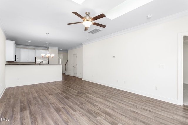 unfurnished living room featuring visible vents, baseboards, ornamental molding, ceiling fan with notable chandelier, and wood finished floors