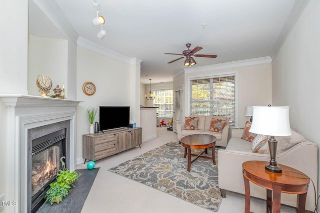 living room with a fireplace with flush hearth, crown molding, and ceiling fan with notable chandelier