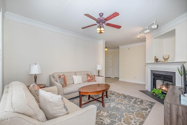 living area with crown molding, a fireplace with flush hearth, carpet flooring, ceiling fan, and baseboards