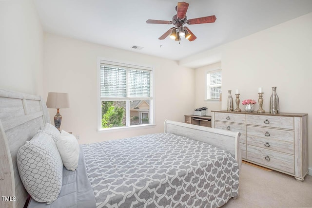 bedroom featuring visible vents, a ceiling fan, and light colored carpet