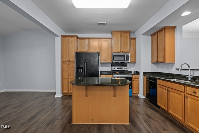 kitchen featuring visible vents, dark wood-style flooring, a center island, black appliances, and a sink