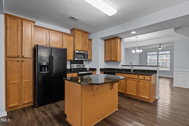 kitchen featuring stainless steel appliances, dark wood-type flooring, a peninsula, a sink, and visible vents