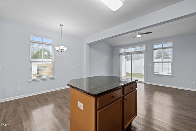 kitchen featuring dark wood-type flooring, a wealth of natural light, open floor plan, and hanging light fixtures