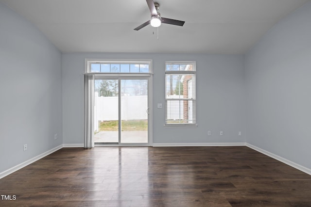 empty room featuring dark wood finished floors, a ceiling fan, and baseboards