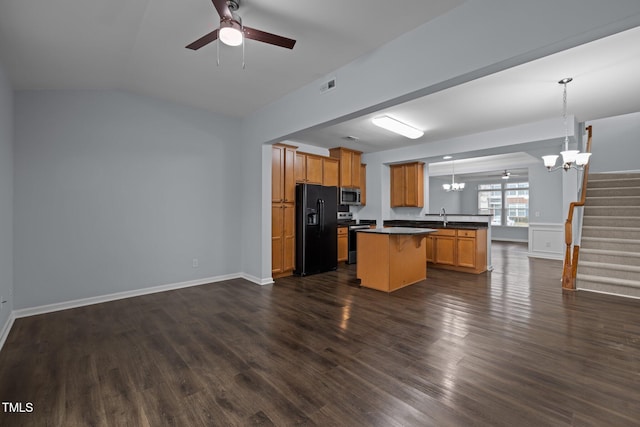 kitchen featuring a breakfast bar area, ceiling fan with notable chandelier, open floor plan, appliances with stainless steel finishes, and dark countertops