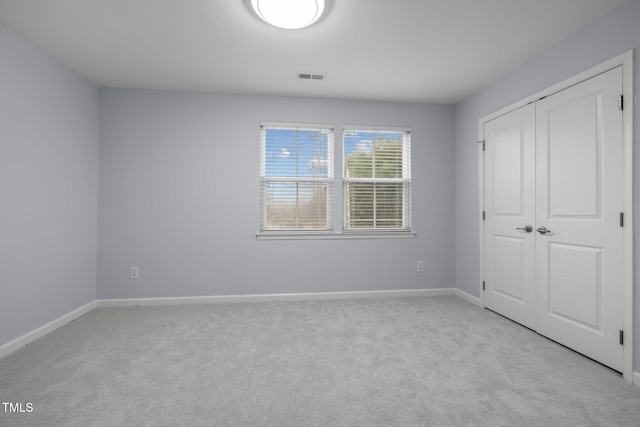 unfurnished bedroom with a closet, baseboards, visible vents, and carpet flooring