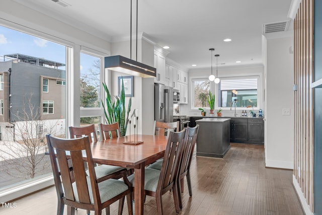 dining area featuring recessed lighting, visible vents, ornamental molding, and wood finished floors