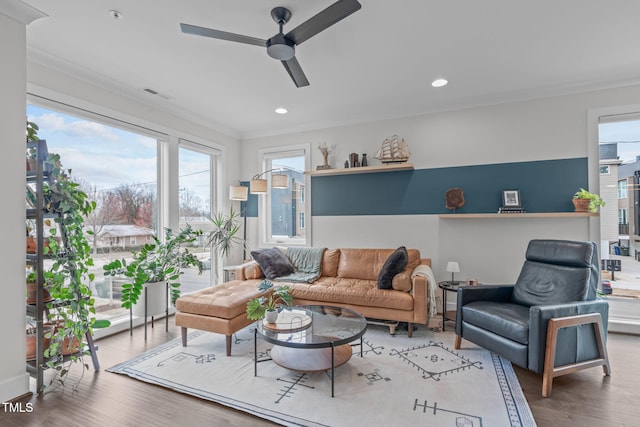 living room with visible vents, recessed lighting, crown molding, and wood finished floors