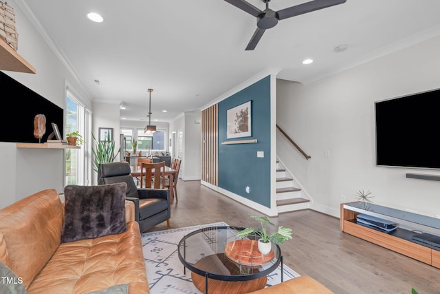 living room featuring crown molding, stairway, and wood finished floors